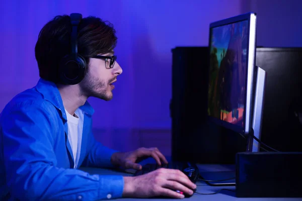 Concentrado chico jugando juego de disparos, usando auriculares — Foto de Stock