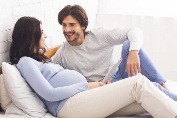 Esperando pareja usando tableta digital juntos en casa —  Fotos de Stock