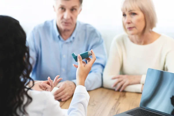 Artsen die astma-inhalator geven aan oudere paren — Stockfoto