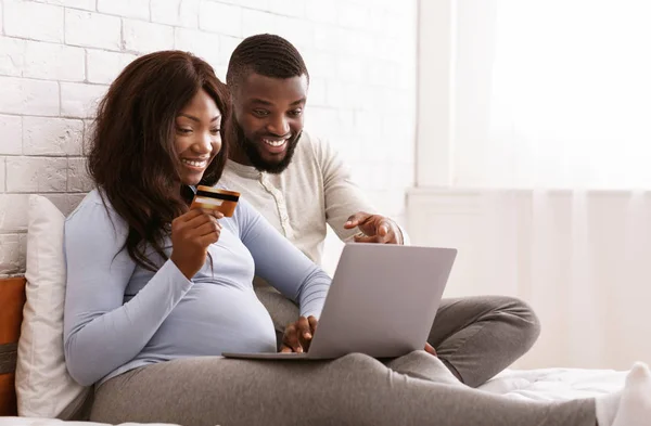 Happy expectant couple shopping online, using laptop — Stock Photo, Image