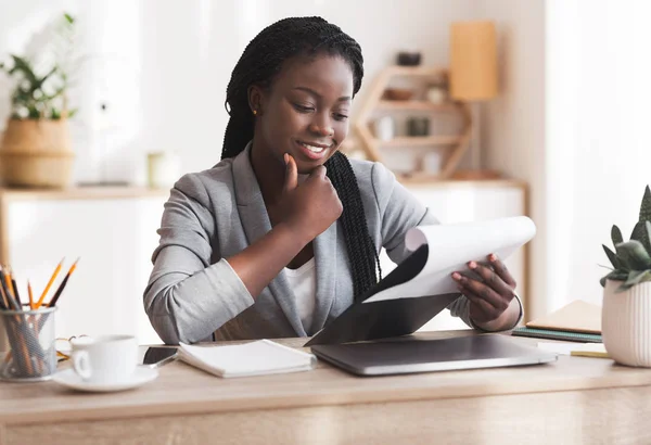 Nachdenkliche schwarze Geschäftsfrau überprüft Finanzberichte am Arbeitsplatz im Büro — Stockfoto