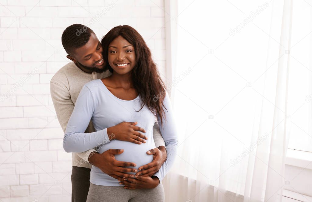 Man in love hugging his pregnant wife over white