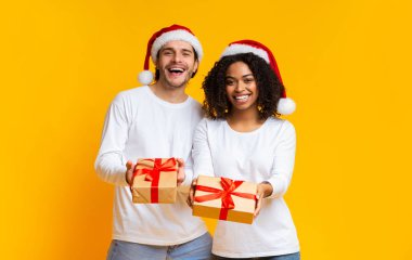 Neşeli milenyum çifti kameraya Noel hediyelerini uzatıyor