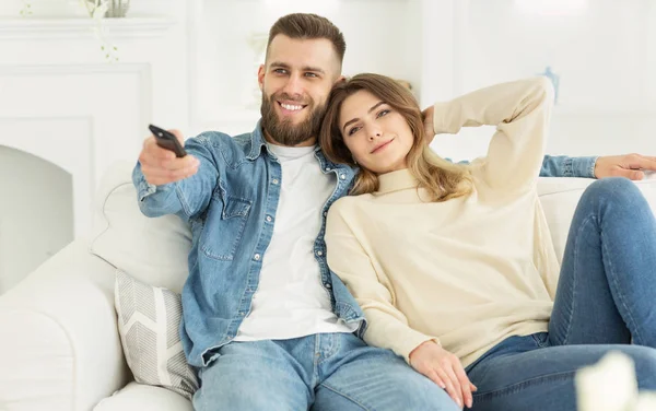 Sorrindo jovem casal assistindo TV e relaxando em casa — Fotografia de Stock