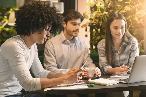 Collega 's plannen nieuw project, jonge man op zoek naar info — Stockfoto