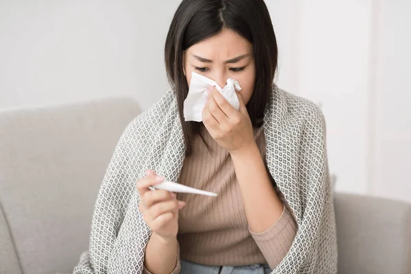 Menina asiática com febre, medir a temperatura corporal — Fotografia de Stock