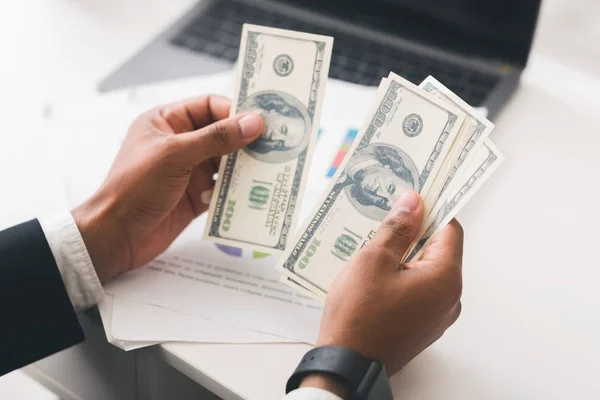 Gehakt van zakenlieden die dollarbankbiljetten tellen op de werkplek — Stockfoto