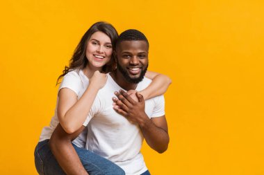 Afro adam kız arkadaşına sırtına biniyor.