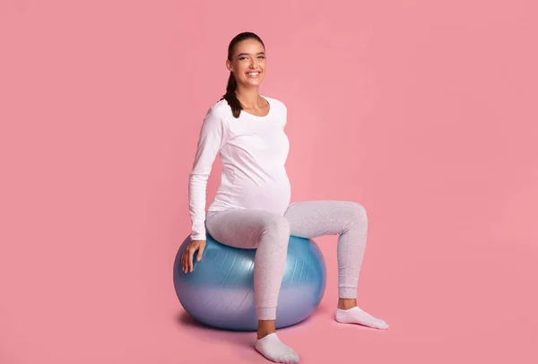 Donna incinta seduta su Fitball che esercita in studio — Foto Stock