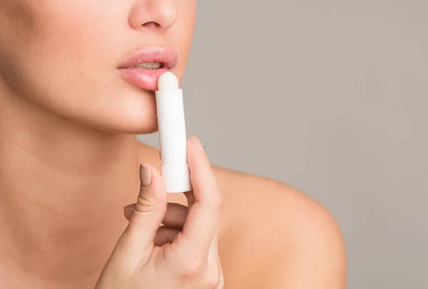 Kvinna tillämpa hygieniska balsam på sina fylliga läppar — Stockfoto
