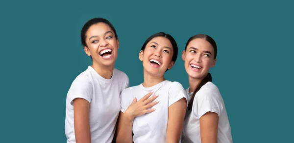 Tres niñas felices y diversas riendo de pie sobre fondo turquesa, Panorama — Foto de Stock
