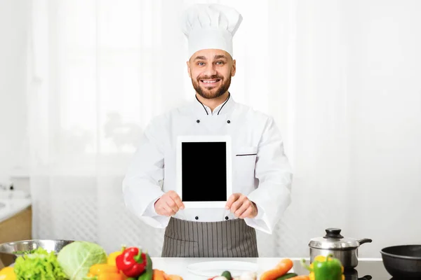 Chef hombre mostrando tableta vacía pantalla publicidad aplicación en la cocina — Foto de Stock