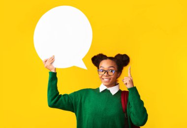 Stüdyoda beyaz konuşma balonu tutan siyah bir genç.