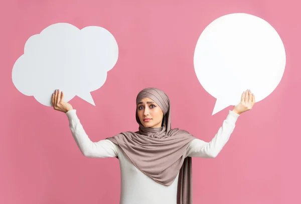 Two speech bubbles in hands of islamic girl in hijab