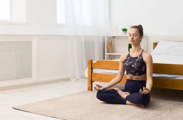 Jeune femme faisant du yoga à la maison en position lotus — Photo
