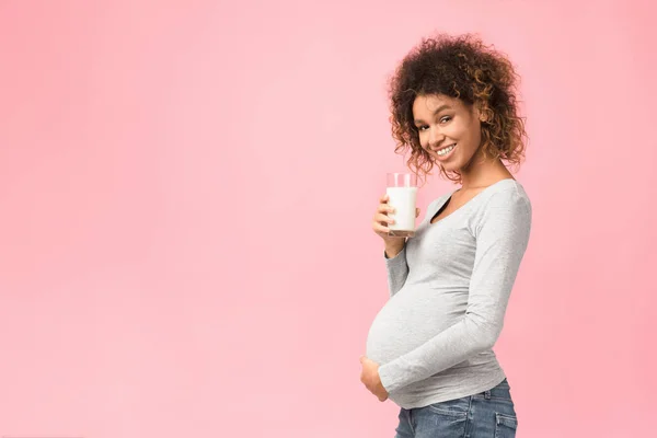 Afro gravid kvinna som håller glas mjölk, fritt utrymme — Stockfoto