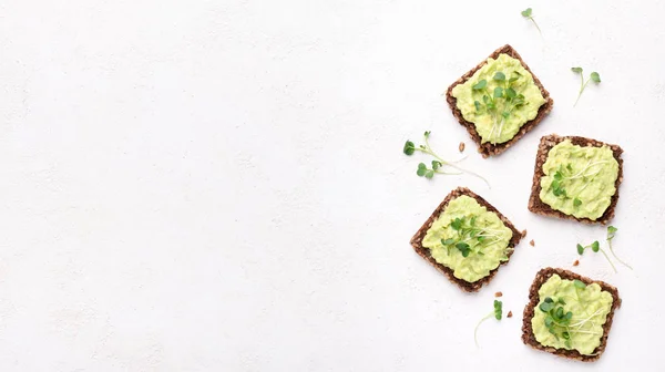 Trendy sandwiches with avocado spread and microgreen — Stock Photo, Image