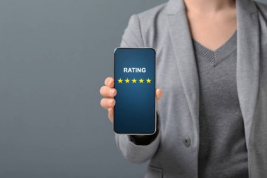 İş kadını cep telefonundan memnuniyeti için beş yıldız gösteriyor.