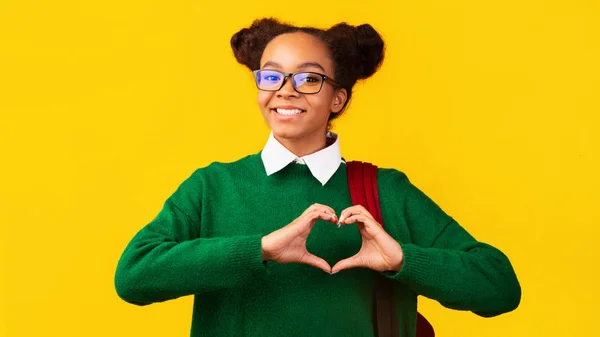 Lächelndes schwarzes Mädchen zeigt Herz-Geste mit Fingern — Stockfoto