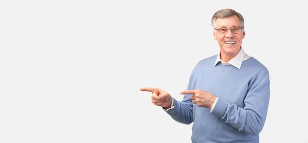 Älterer Mann zeigt mit dem Finger zur Seite auf weißem Hintergrund, Panorama — Stockfoto