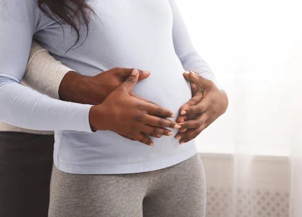 Jong getrouwd stel verwacht baby, knuffelen thuis — Stockfoto