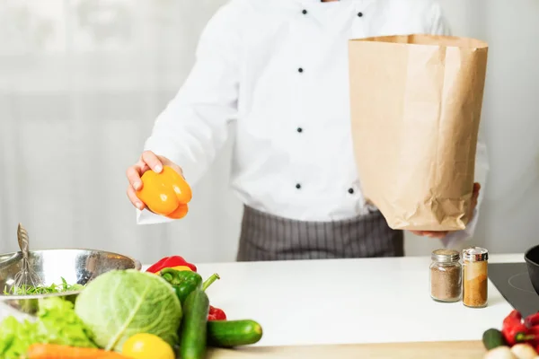 Chef irreconocible Desembalaje Bolsa de la compra de comestibles en la cocina del restaurante, recortado — Foto de Stock