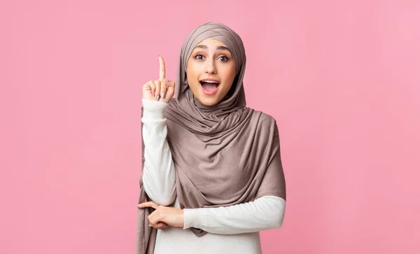 Aufgeregte Araberin im Hijab zeigt mit erhobenem Zeigefinger auf Idee — Stockfoto