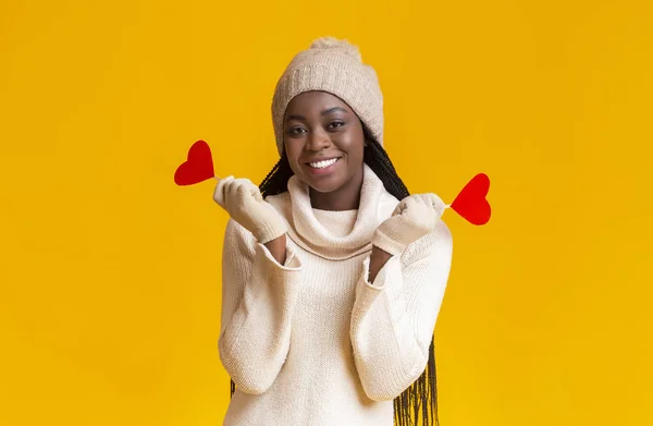 Sorrindo menina de inverno preto segurando cartões valentine vermelho — Fotografia de Stock