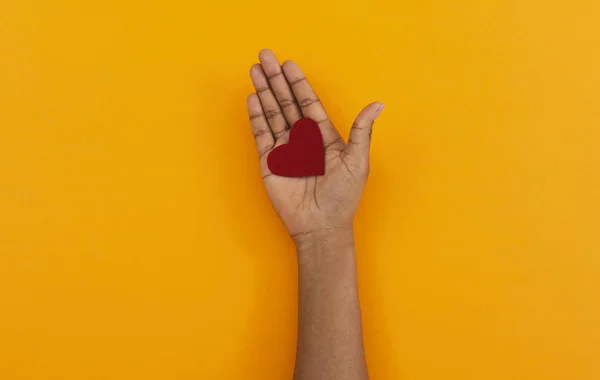 Coração sentido vermelho na palma aberta da mulher negra — Fotografia de Stock