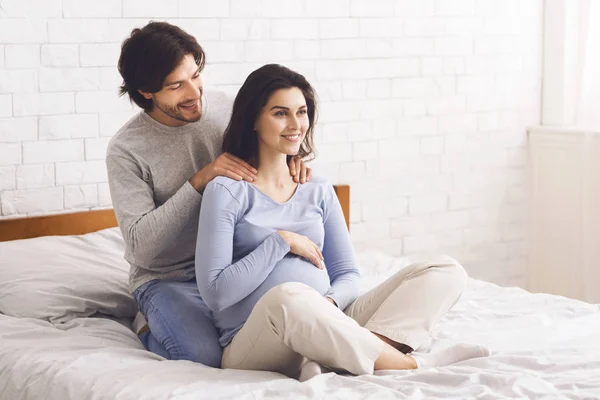 Caring marito facendo massaggio alla sua felice moglie incinta — Foto Stock