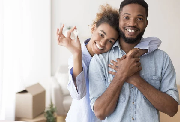 Afro Spouses Showing Key To Camera Embracing In New Home — Stock Photo, Image