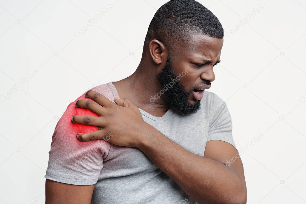 Young man suffering from pain in shoulder