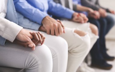 Bir grup insan el ele tutuşuyor, sıraya diziliyorlar.