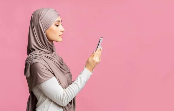Elinde akıllı telefon olan ciddi bir İslami kadının profil portresi — Stok fotoğraf