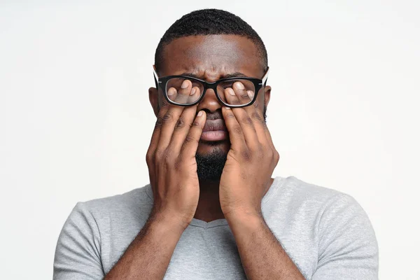 Afro guy in glasses rubbing his eyes — Stock Photo, Image