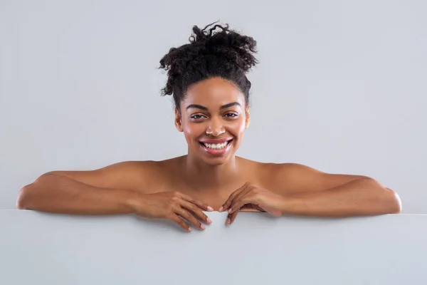 Senyum wanita telanjang hitam berpose di atas latar belakang abu-abu — Stok Foto