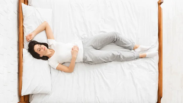 Millennial žena spí v posteli,, pohled shora — Stock fotografie