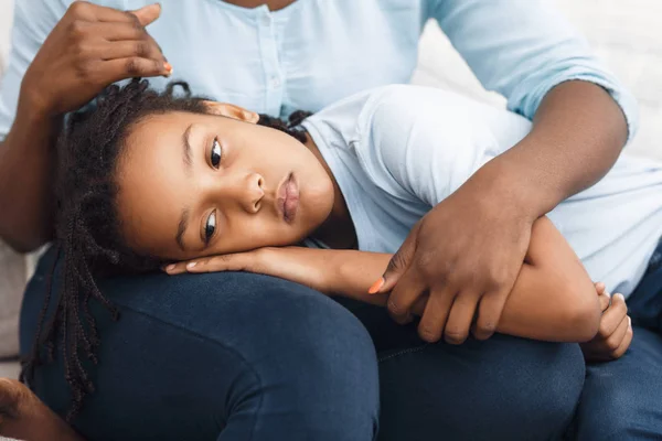 Black daughter lying her head on moms lap — 스톡 사진