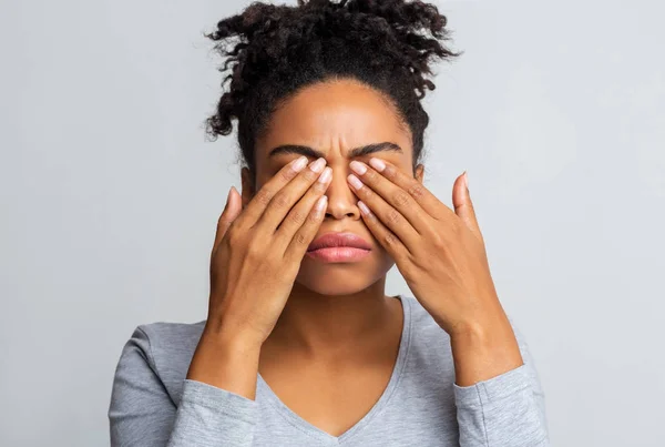 Menina negra esfrega os olhos, sofrendo de conjuntivite — Fotografia de Stock