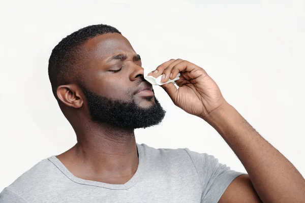 Hombre tocándose la nariz con servilleta, sangrando — Foto de Stock