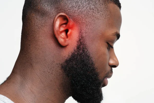 Svart kille med inflammerat öra, sidovy — Stockfoto