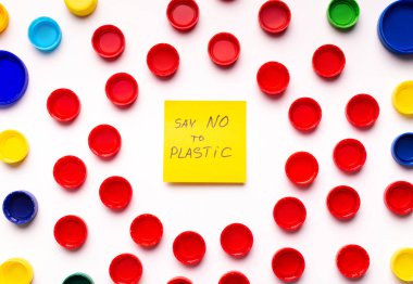 İçinde metin olan plastik şişelerden renkli kapaklar.