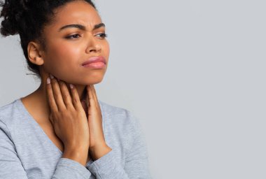 Afro woman suffering from sore throat, touching her neck clipart