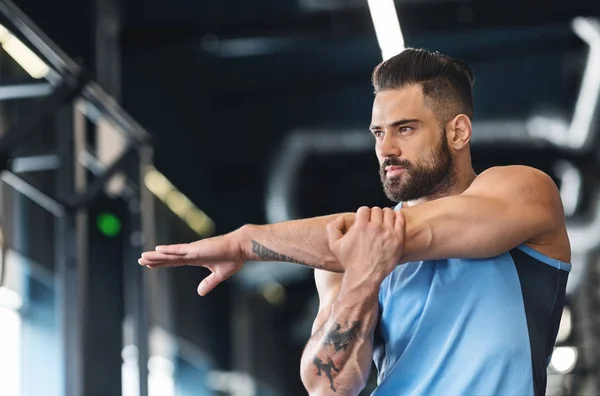 Sportler streckt seine Hände vor dem Training im Fitnessstudio — Stockfoto