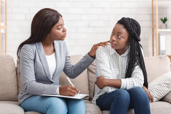 Psychotherapist comforting sad female patient during therapy session in office — Stock Photo, Image