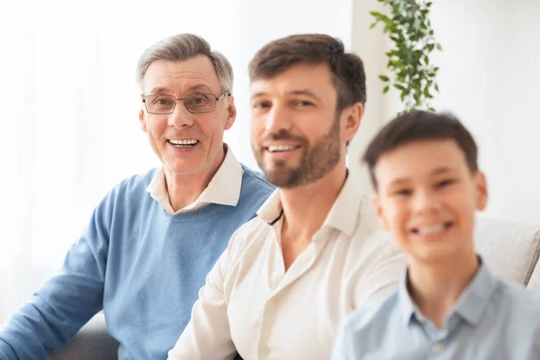 Uomo anziano, figlio e nipote seduti sul divano di casa — Foto Stock