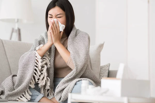 Sick at home. Girl blowing runny nose in napkin — Stock Photo, Image