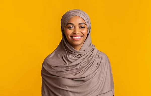 Portrét skromné černošky muslimské dívky v hidžábu přes žluté pozadí — Stock fotografie