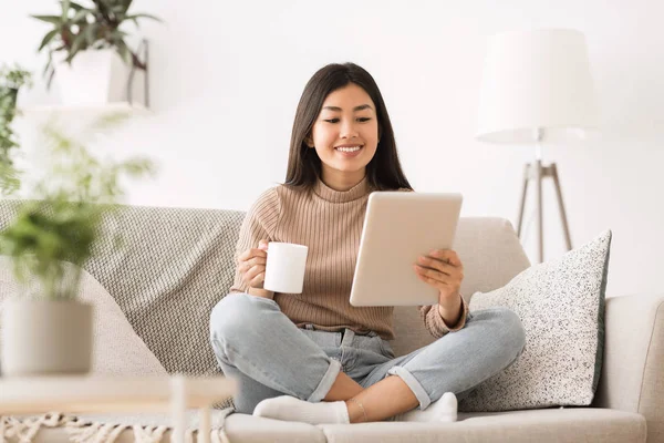 Cheerful girl reading e-book on digital tablet — 스톡 사진