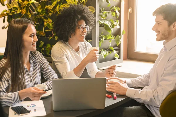 Millennial kollegor njuter av kaffe och diskuterar arbete på café — Stockfoto